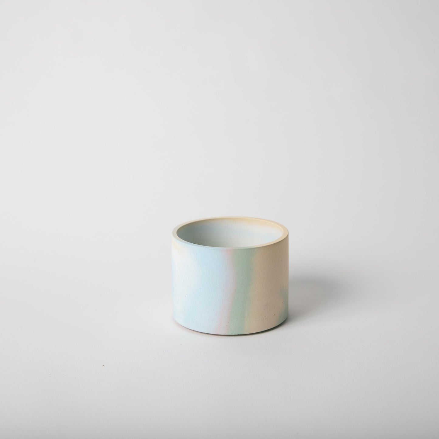 4 inch concrete vessel with cork base in jawbreaker (rainbow color).