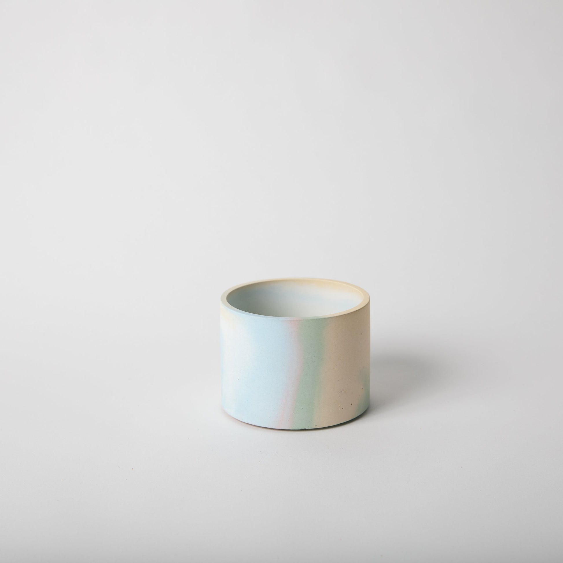 4 inch concrete vessel with cork base in jawbreaker (rainbow color).