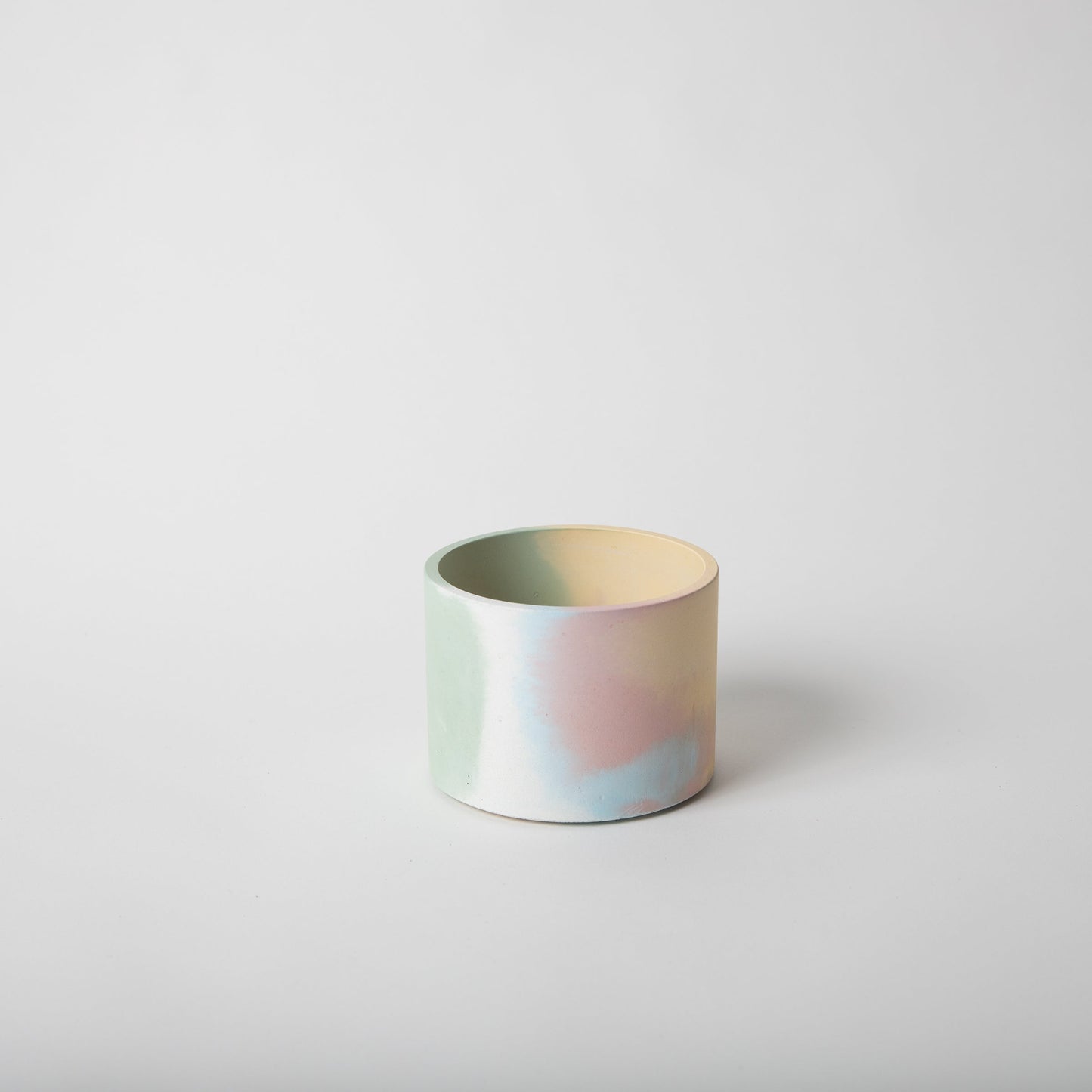 4 inch concrete vessel with cork base in jawbreaker (rainbow color).