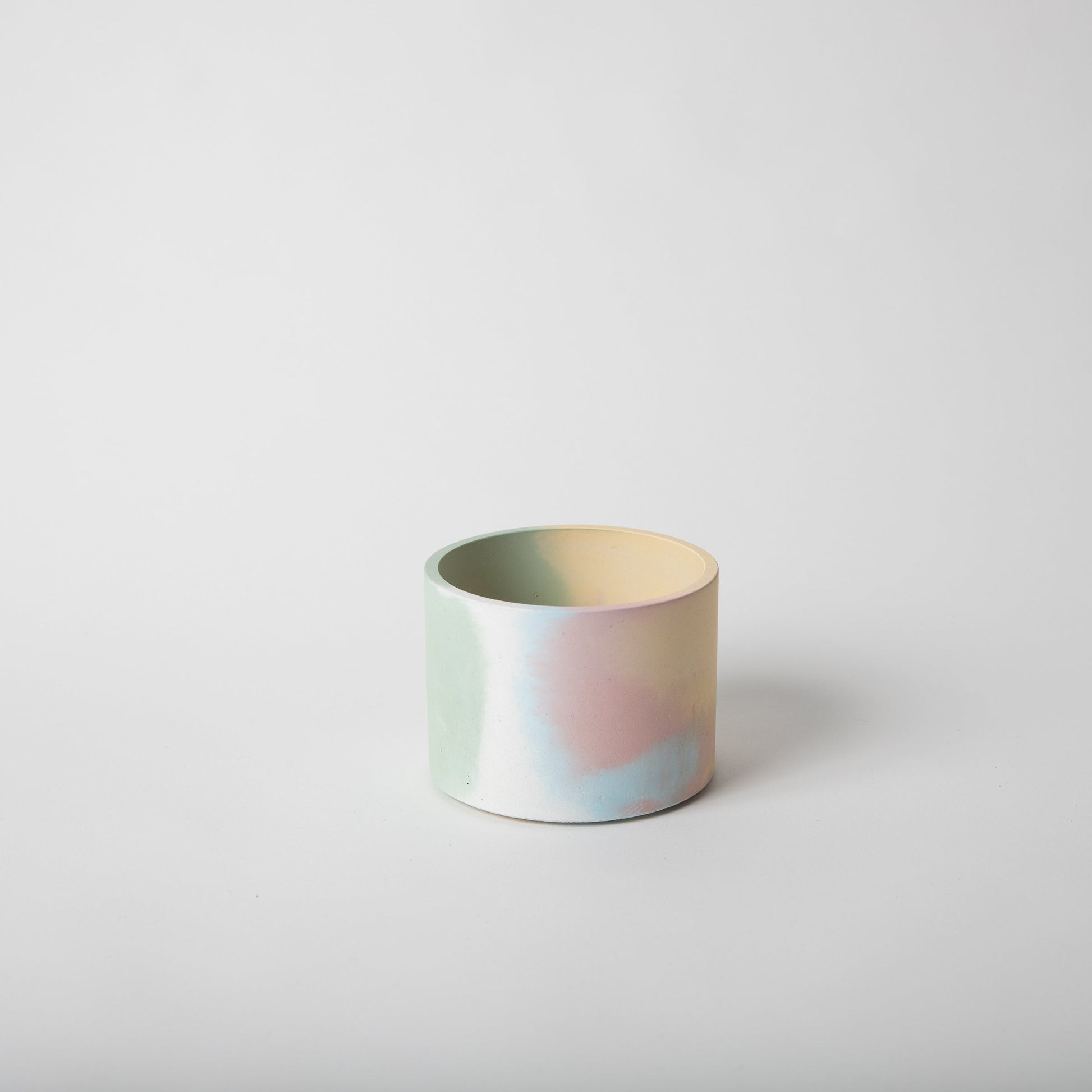 4 inch concrete vessel with cork base in jawbreaker (rainbow color).