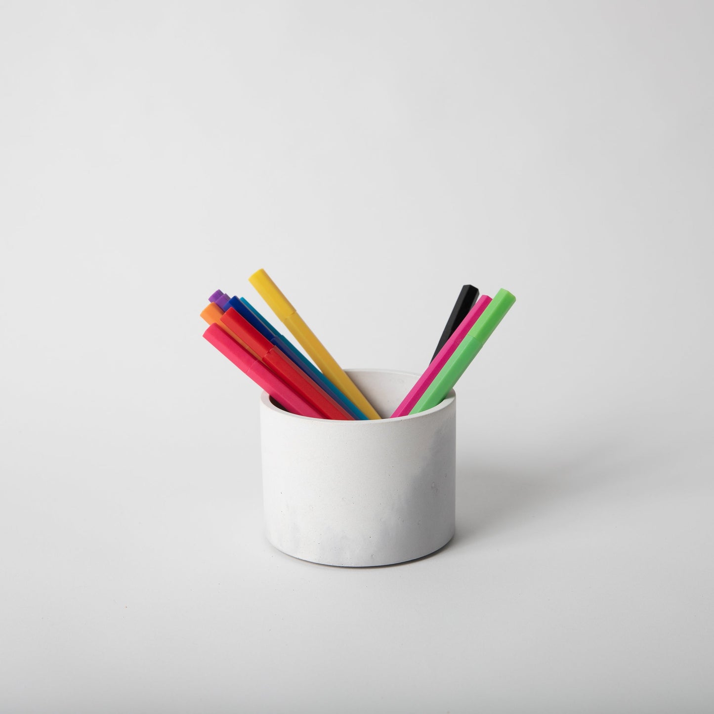 4 inch concrete vessel with cork base in grey and white holding pens.