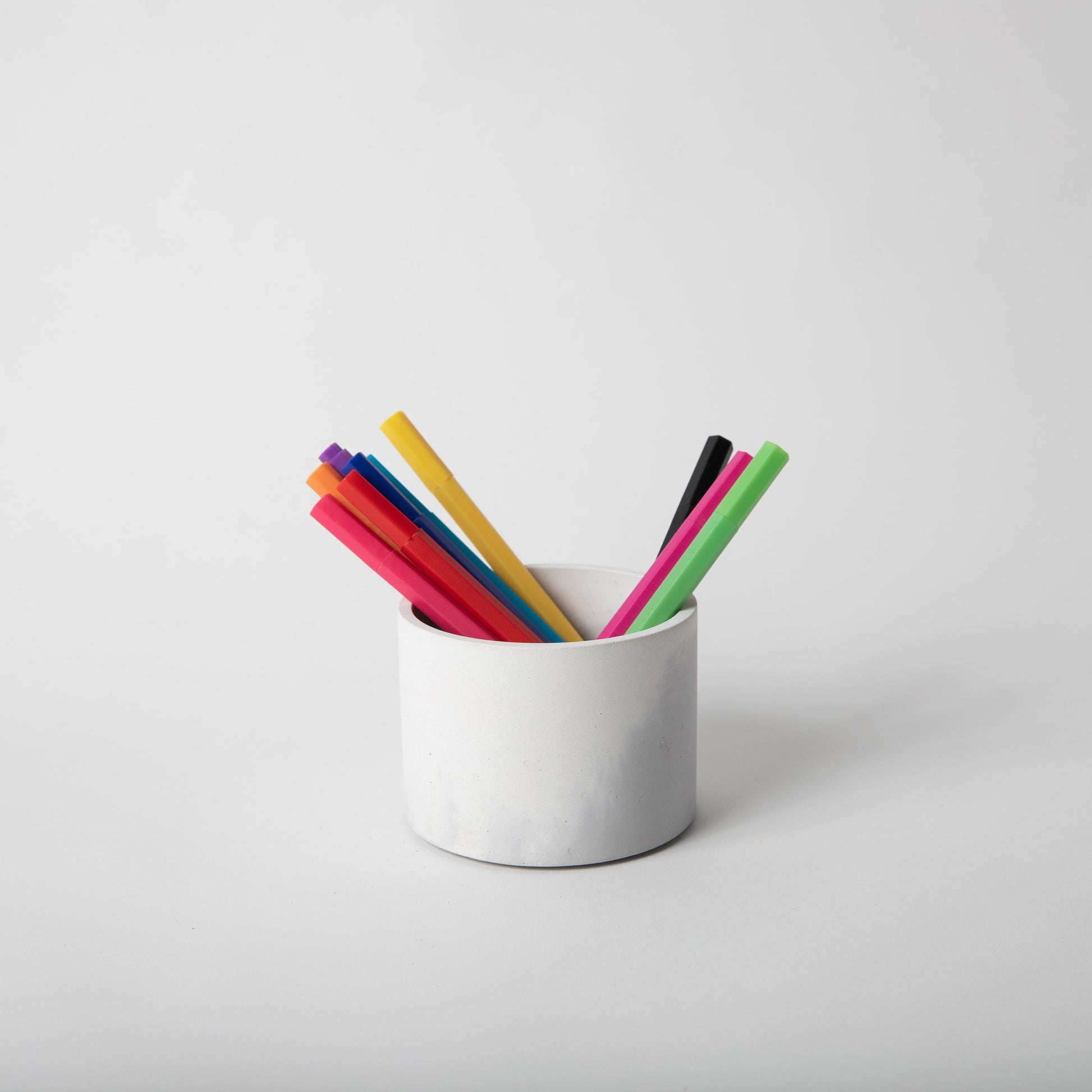 4 inch concrete vessel with cork base in grey and white holding pens.