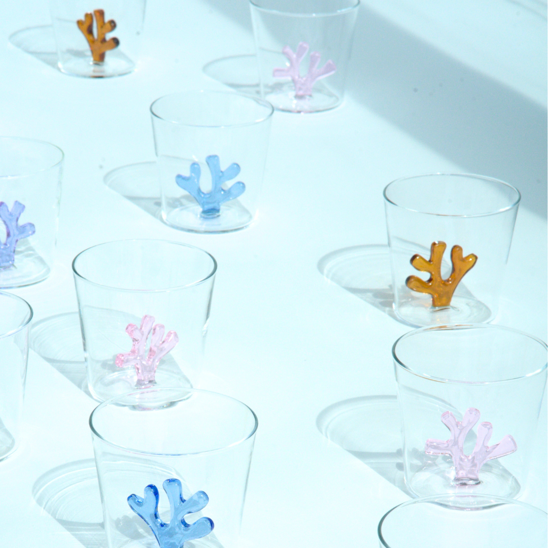colored glass tumblers in a sunny room. tumblers are available in cobalt blue, blush pink, lavender, and amber