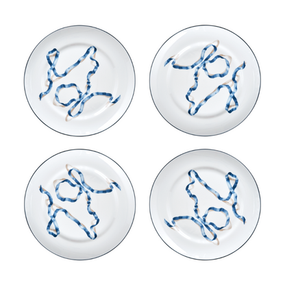 A set of four ribbon dinner plates in Blue. Comprised of a series of ribbon adorned plates, the collection is a delightful departure from traditional holiday decor. The plates are inspired by prints of citrus fruits from the 17th and early 18th centuries showing ribbons bearing the names of the depicted fruit.