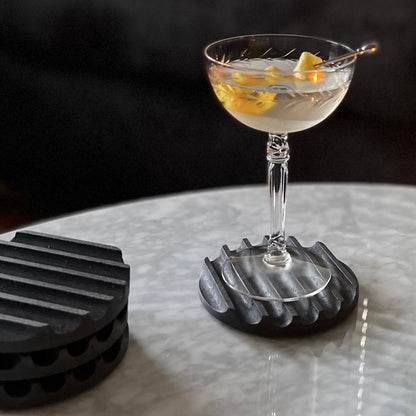 Concrete terrazzo coaster set in black with a glass.